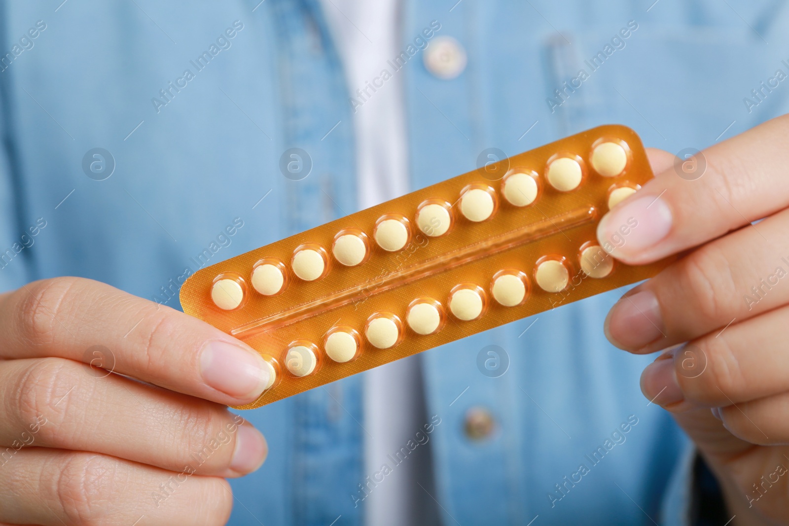 Photo of Woman holding blister with birth control pills, closeup