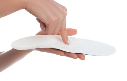 Woman showing orthopedic insole on white background, closeup