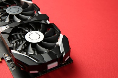 Photo of Computer graphics card on red background, closeup. Space for text