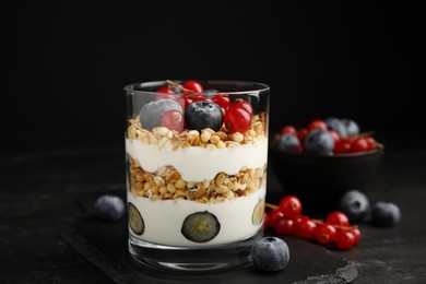 Delicious yogurt parfait with fresh berries on black table, closeup