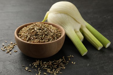 Photo of Fennel seeds in bowl and fresh vegetable on gray table, closeup