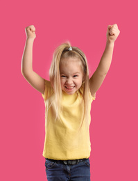 Photo of Portrait of excited little girl on pink background