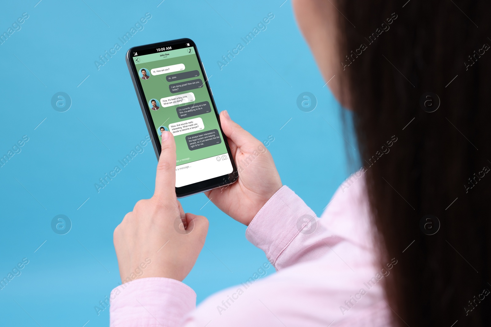Image of Woman texting with friend using messaging application on smartphone against light blue background, closeup