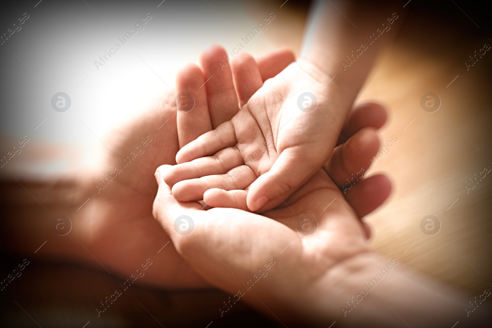 Image of Happy family holding hands on wooden background, closeup