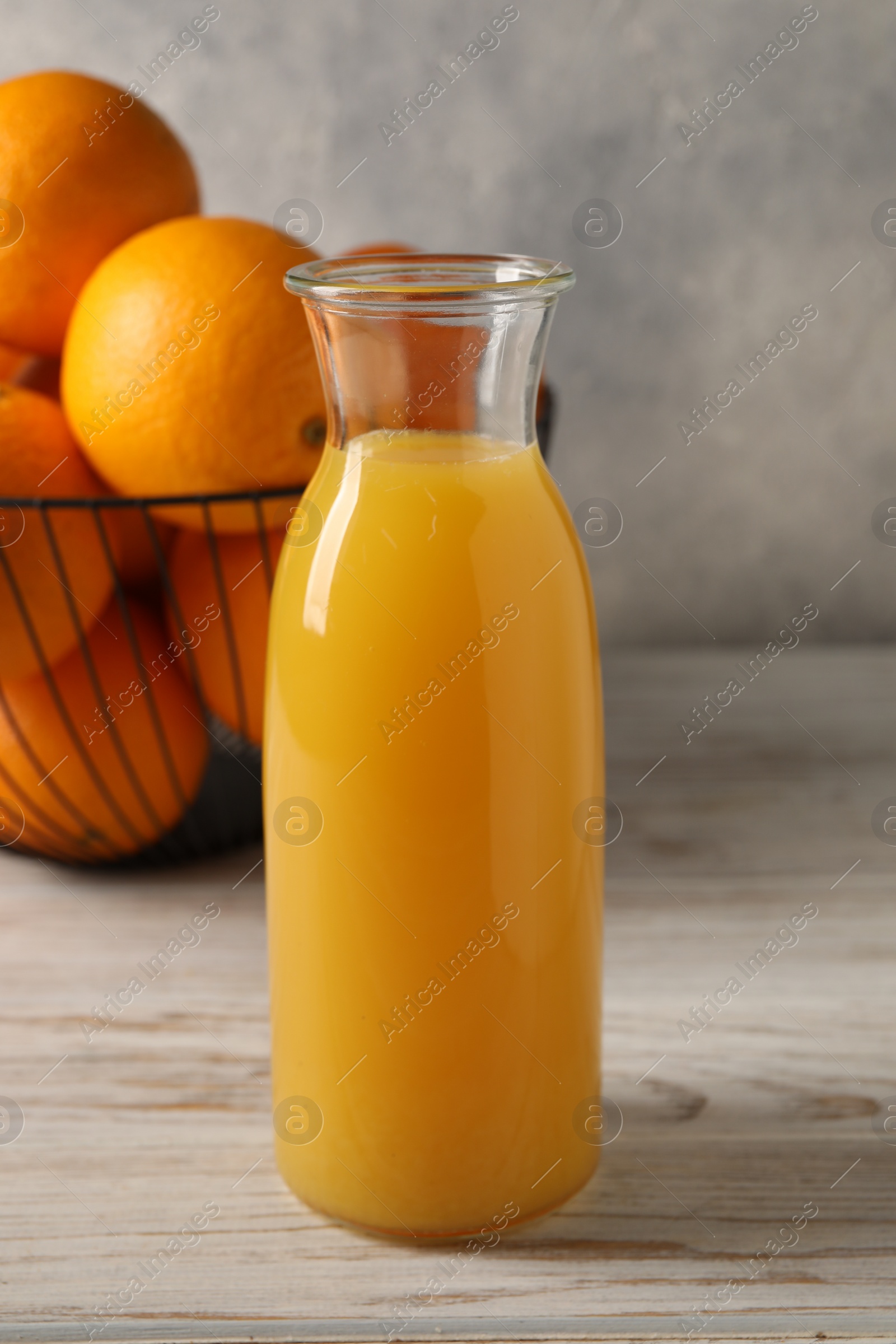 Photo of Tasty fresh oranges and juice in jug on white wooden table