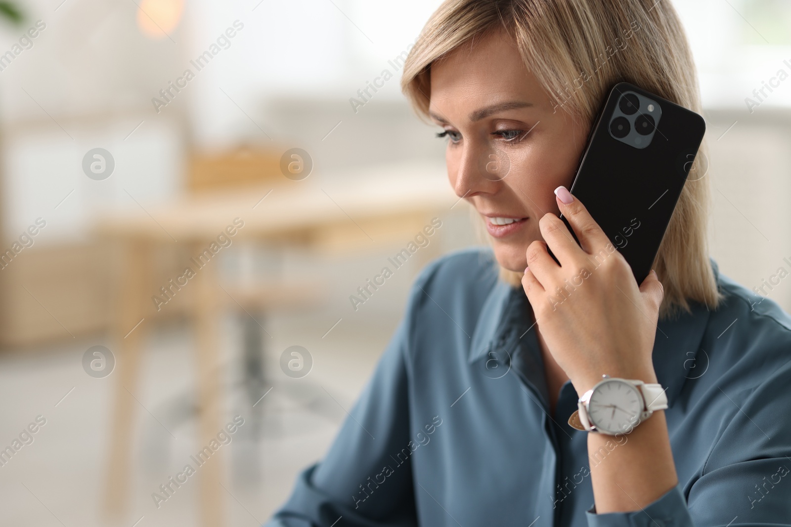 Photo of Happy woman using mobile phone at home