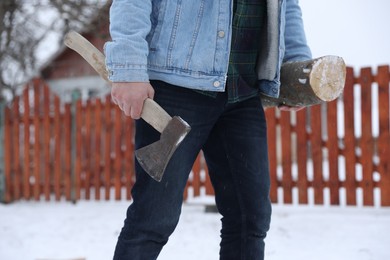 Photo of Man with axe and wood outdoors on winter day, closeup