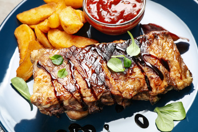 Photo of Delicious grilled ribs in plate, closeup view