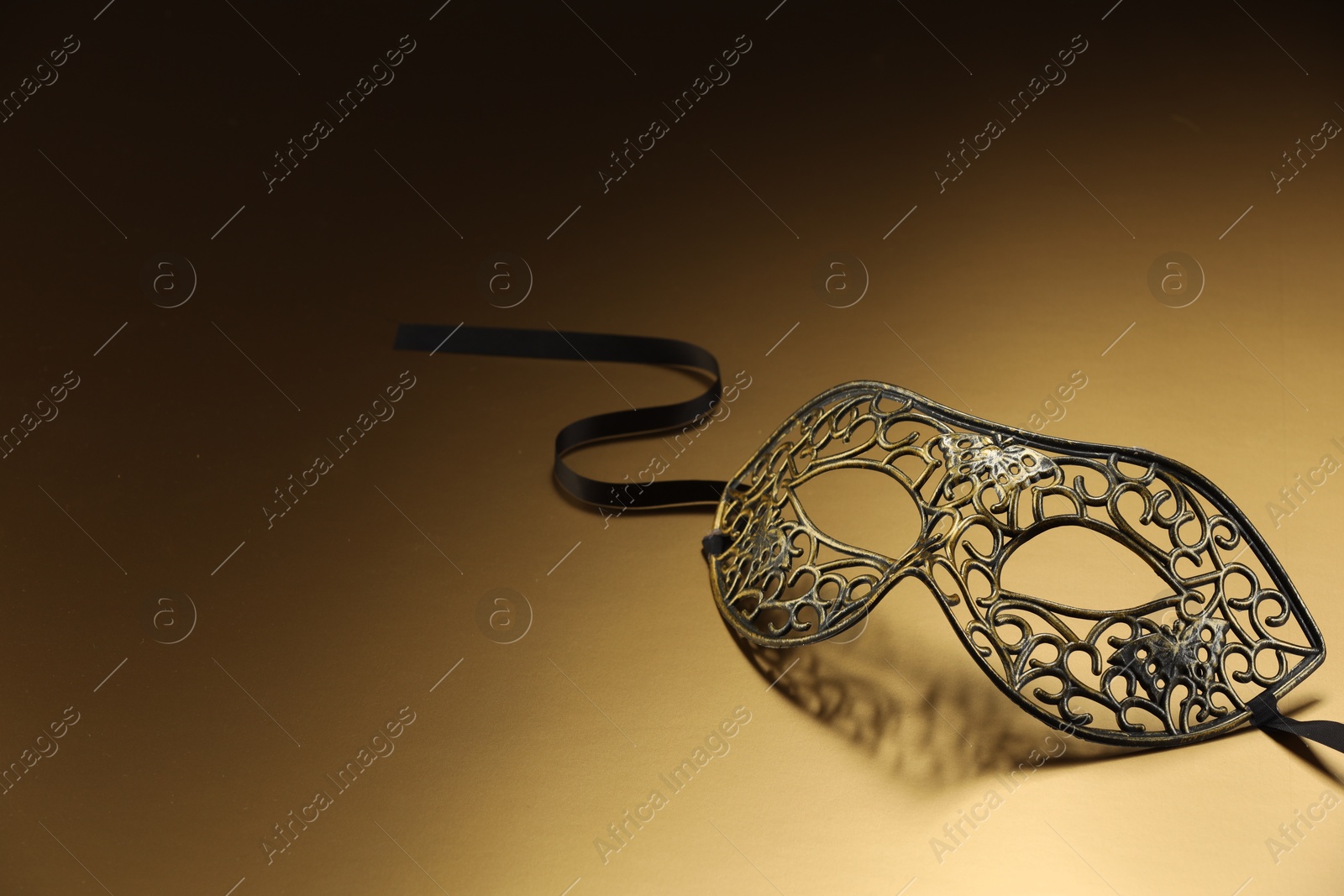 Photo of Elegant face mask on beige background, space for text. Theatrical performance