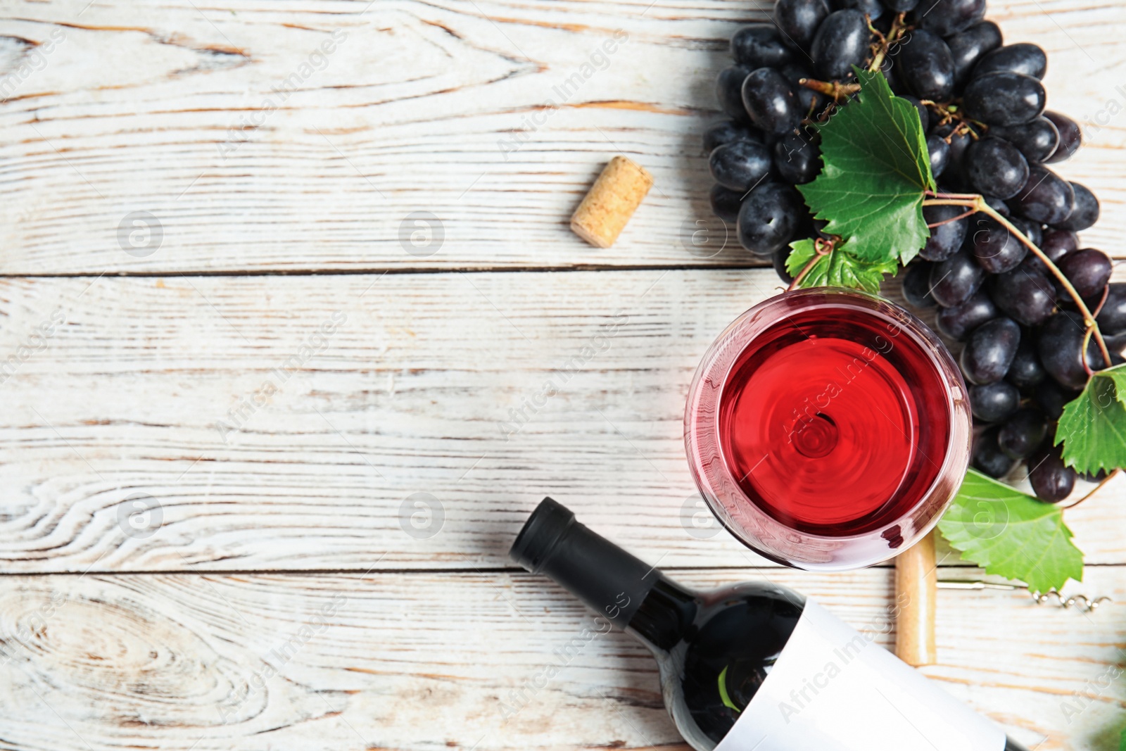 Photo of Flat lay composition with fresh ripe juicy grapes and space for text on wooden background