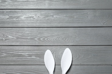 Photo of Funny Easter bunny ears on wooden background, top view with space for text