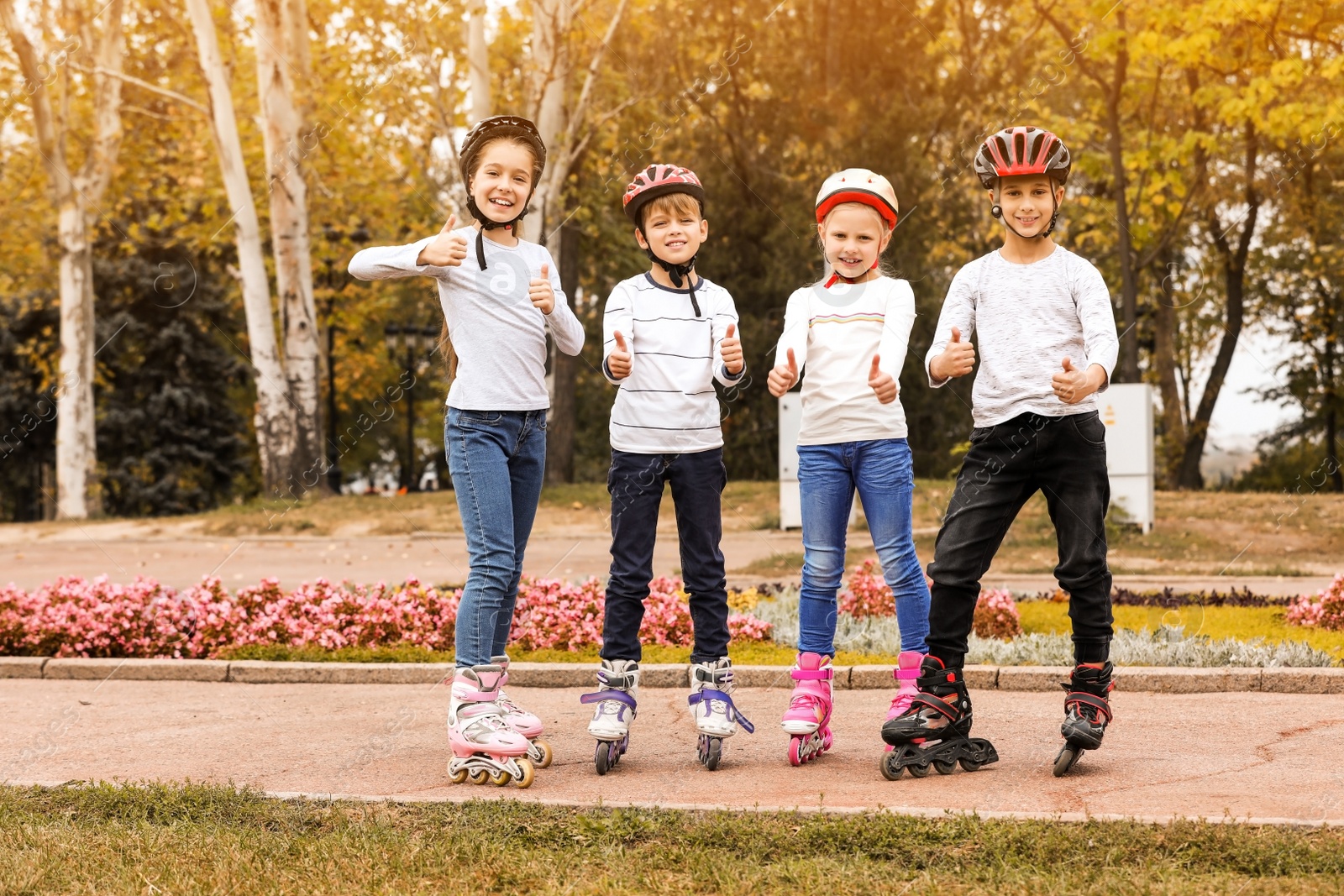 Photo of Happy children wearing roller skates in autumn park