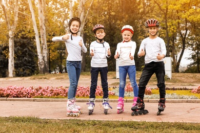 Happy children wearing roller skates in autumn park
