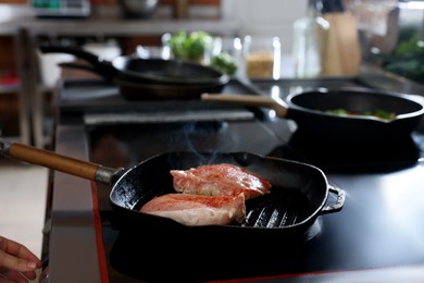 Professional chef cooking meat on stove in restaurant kitchen, closeup