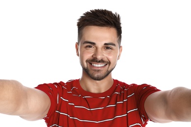 Happy young man taking selfie on white background