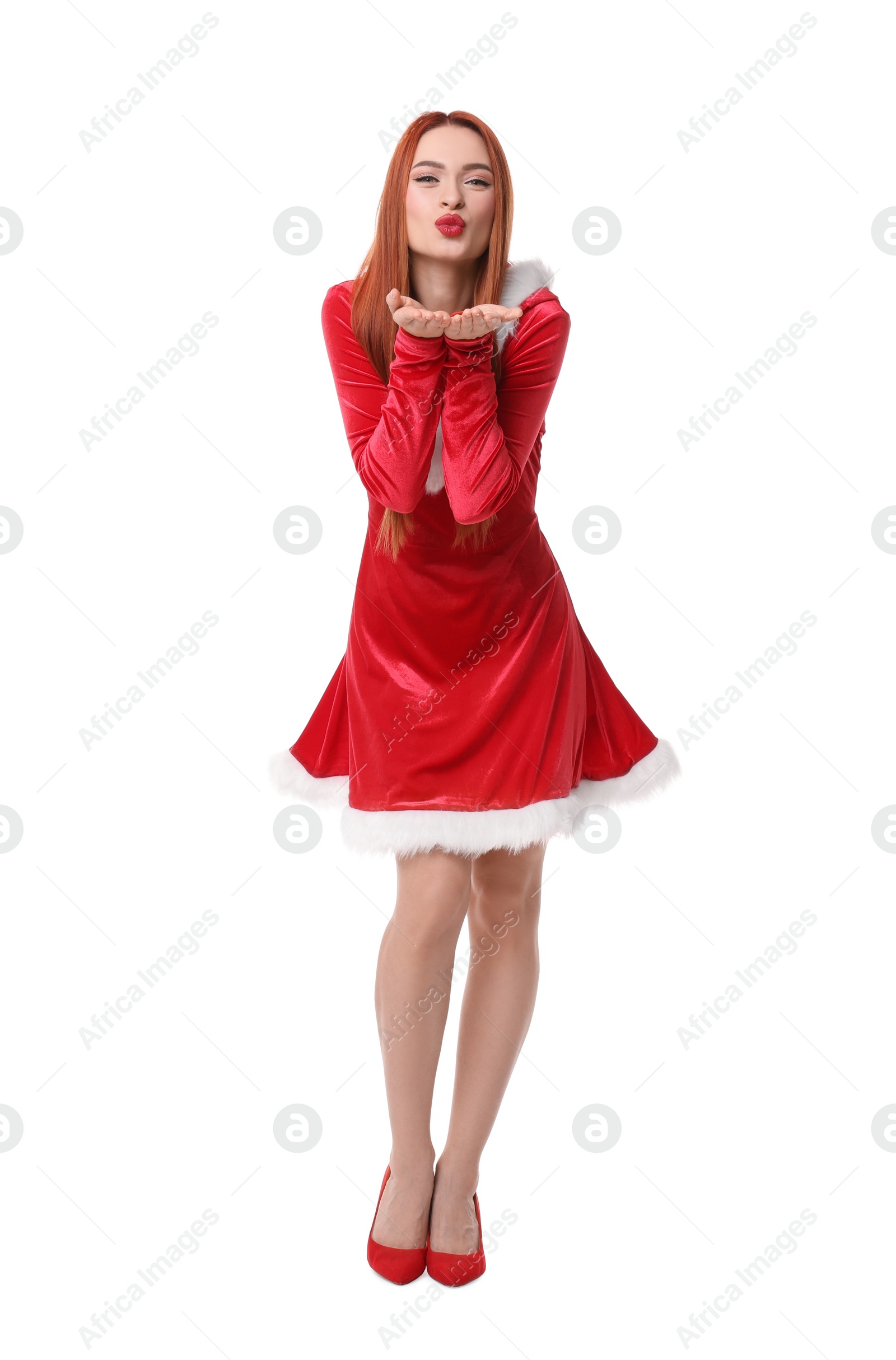 Photo of Young woman in red dress blowing kiss on white background. Christmas celebration