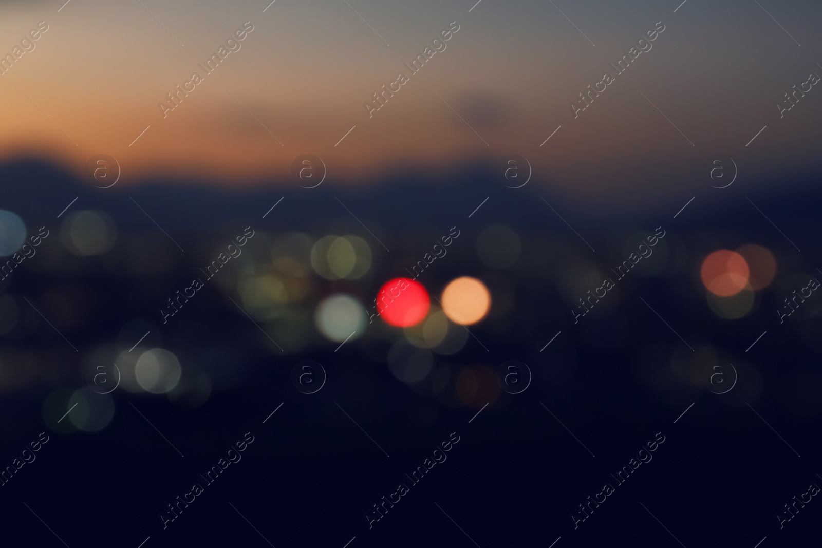 Photo of Blurred view of beautiful sunset with mountains in city, bokeh effect