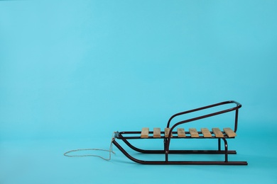 Photo of Stylish sleigh on light blue background, space for text