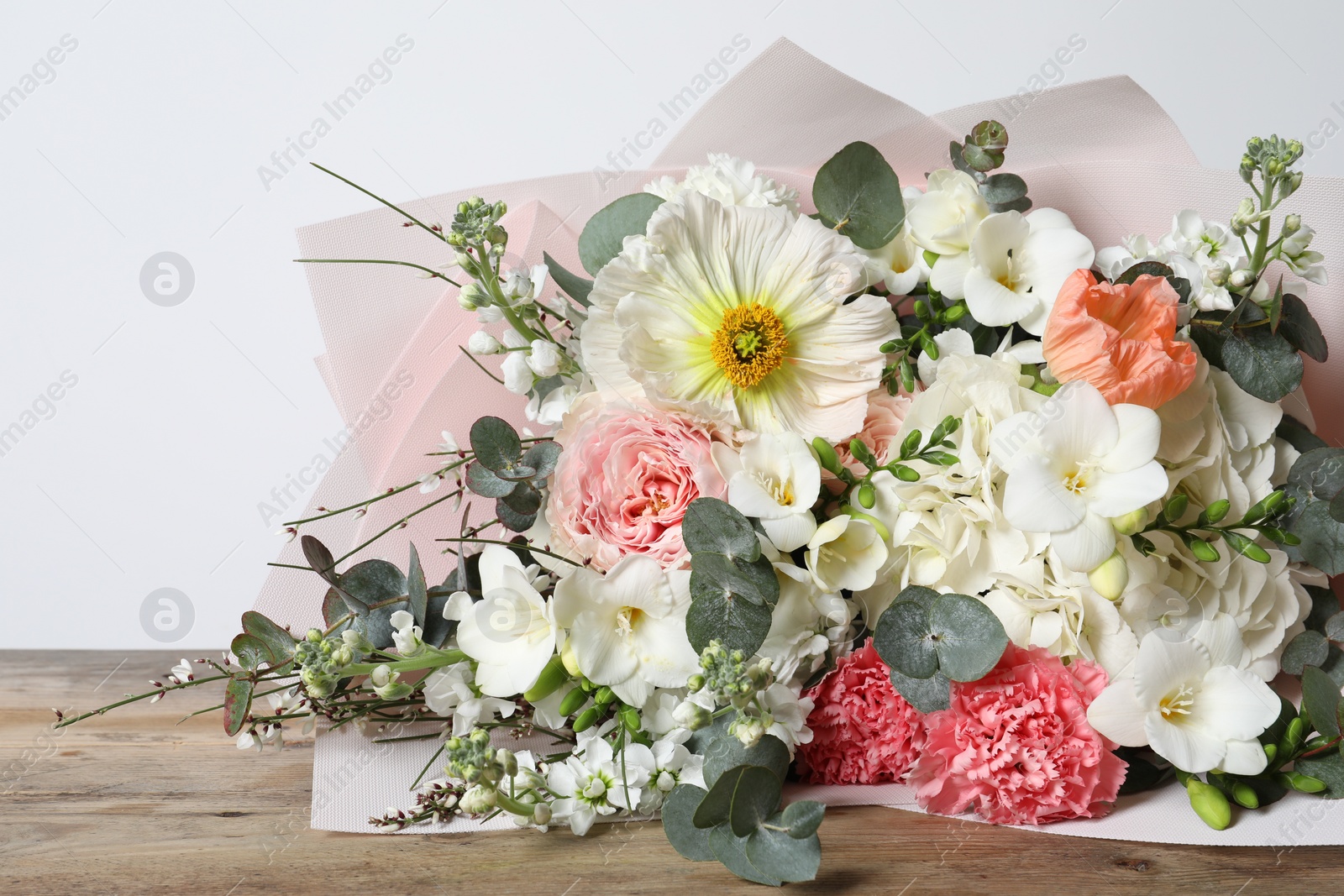 Photo of Bouquet of beautiful flowers on wooden table, closeup