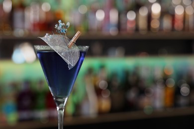 Photo of Fresh alcoholic cocktail in glass against blurred background, closeup. Space for text