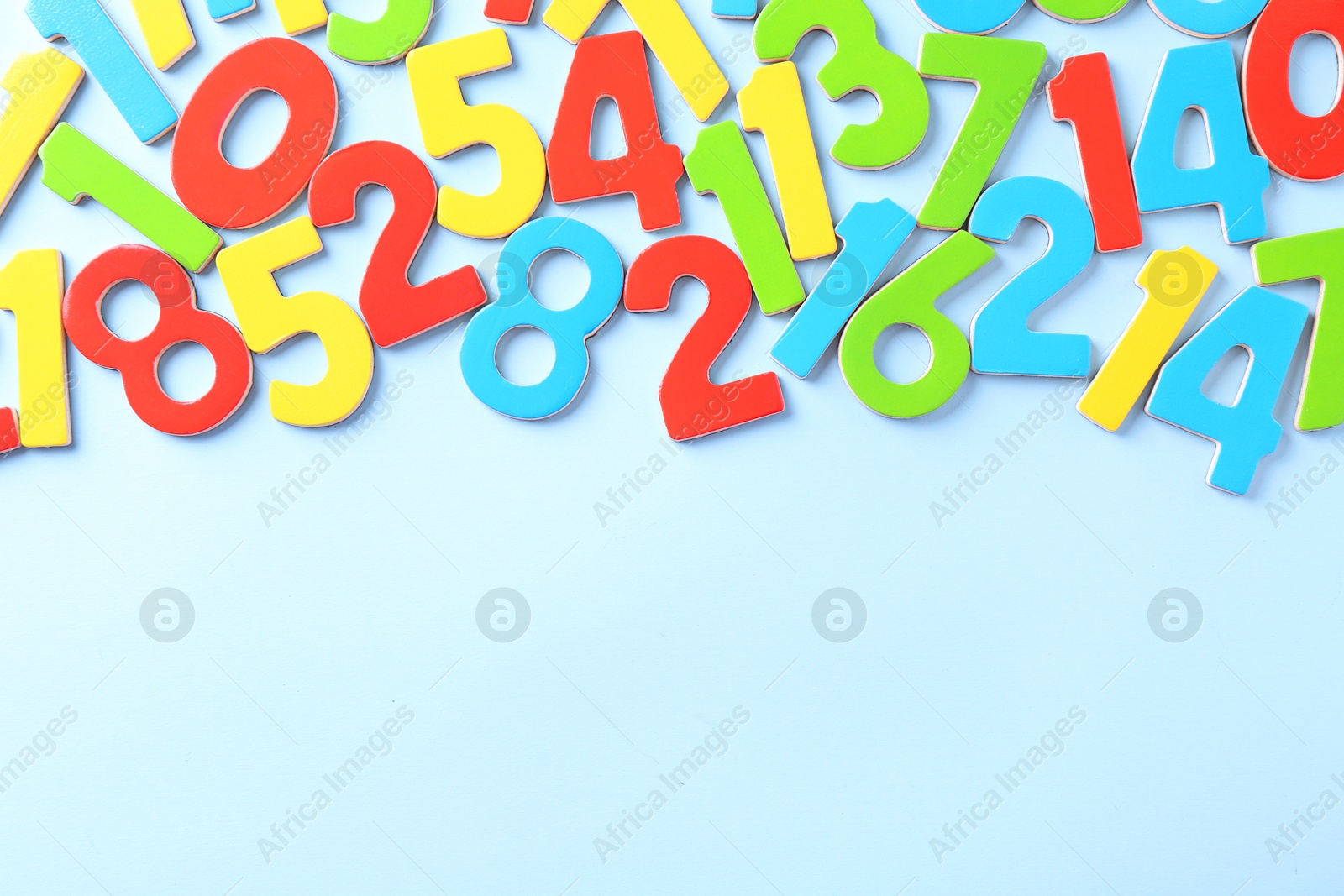 Photo of Colorful numbers on light blue background, flat lay. Space for text