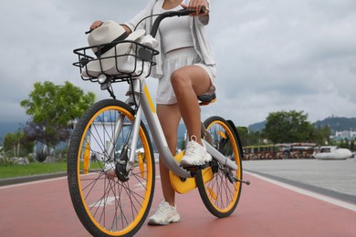 Photo of Young woman with bicycle on lane outdoors, closeup