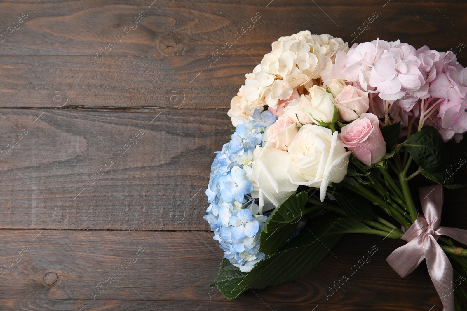 Photo of Bouquet of beautiful hydrangea and rose flowers on wooden background, top view. Space for text