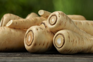 Delicious fresh ripe parsnips on wooden table outdoors, closeup