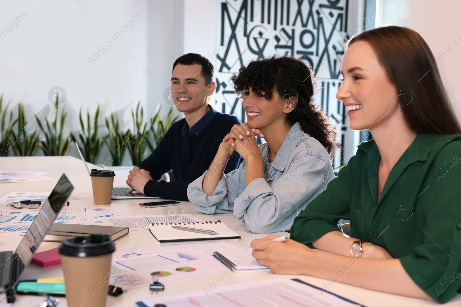 Photo of Team of employees working together at table in office. Startup project