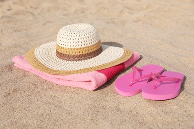 Photo of Beach towel with straw hat and slippers on sand