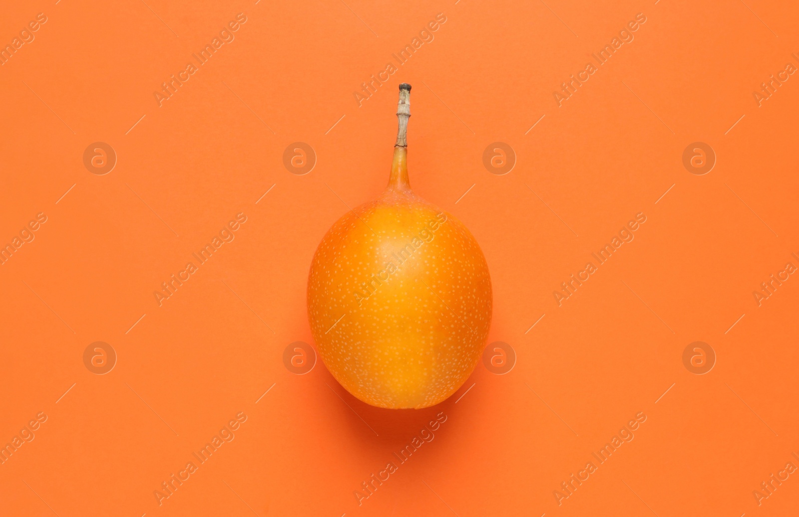 Photo of Delicious ripe granadilla on orange background, top view