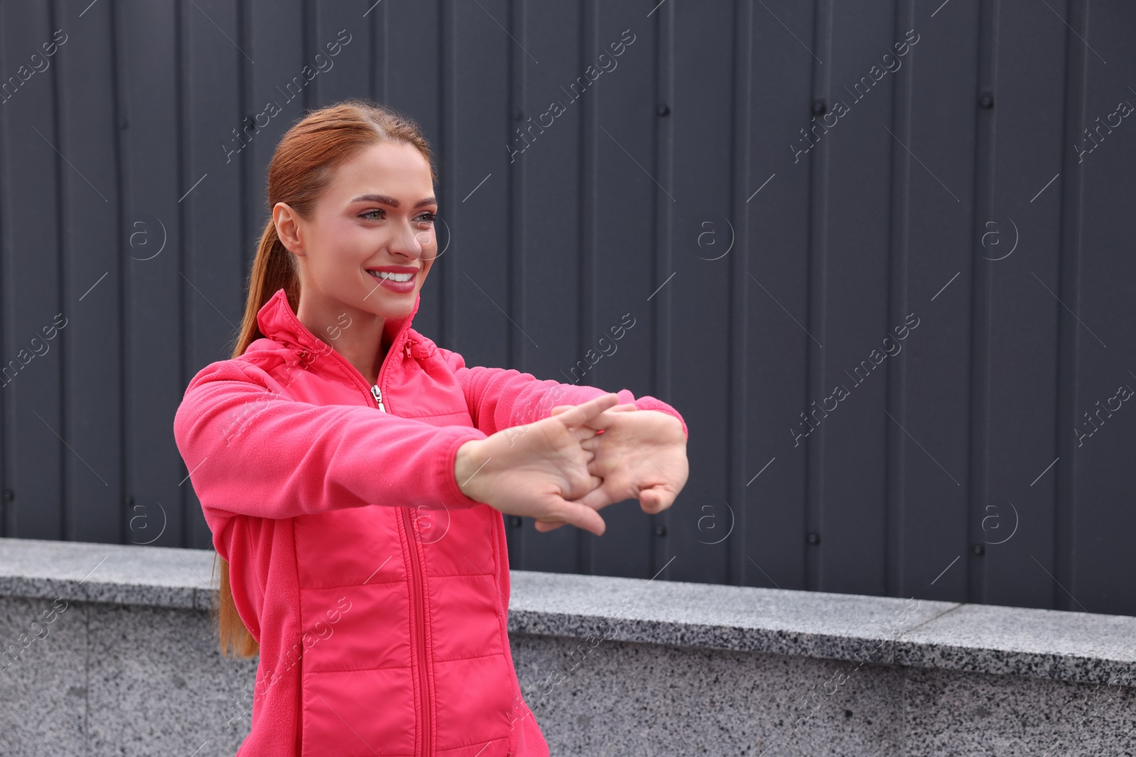 Photo of Beautiful woman in gym clothes doing exercises on street, space for text