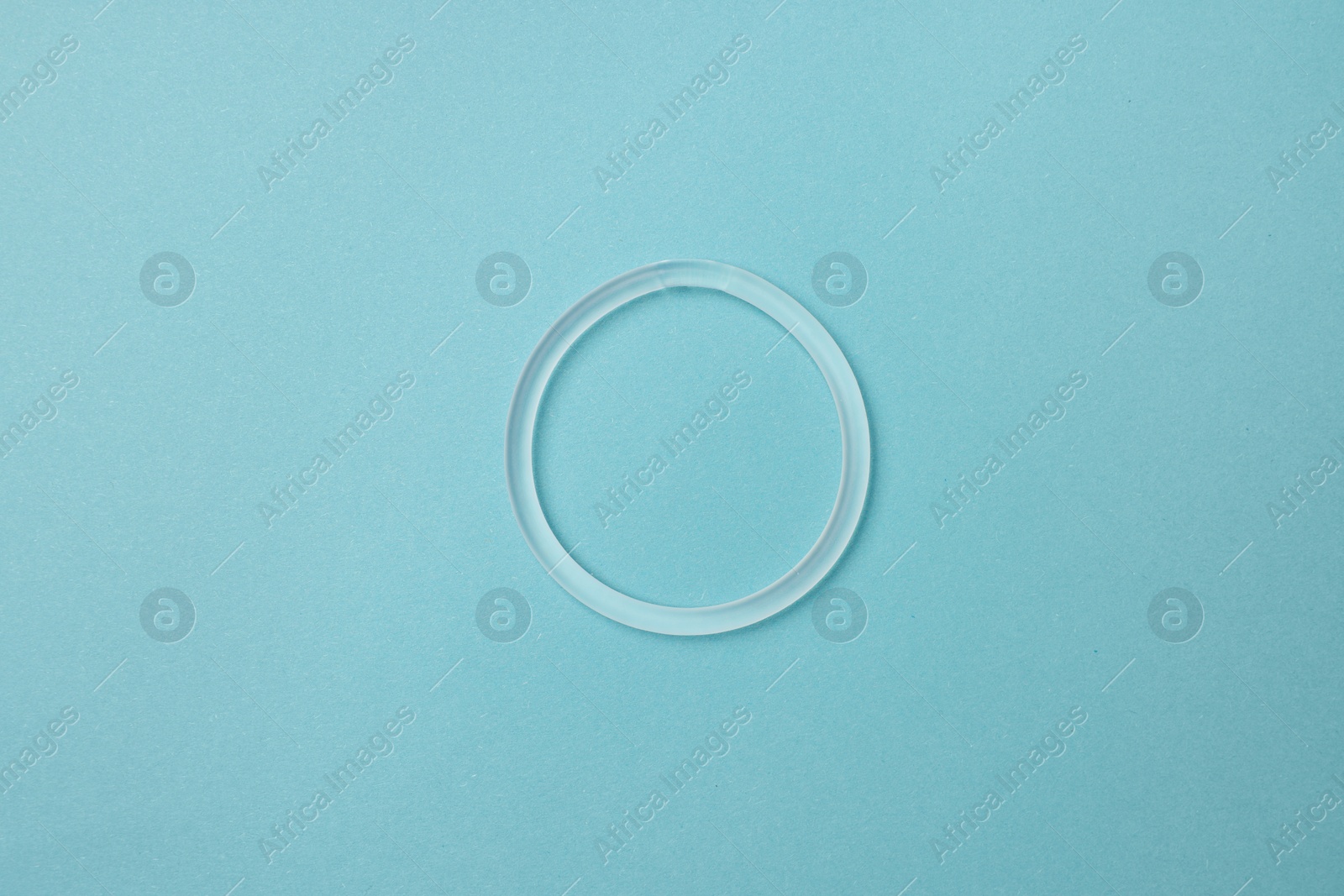 Photo of Diaphragm vaginal contraceptive ring on light blue background, top view