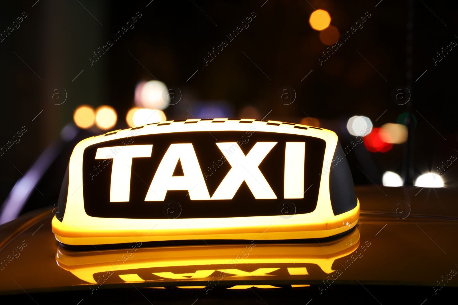 Photo of Taxi car with yellow sign outdoors at night, closeup