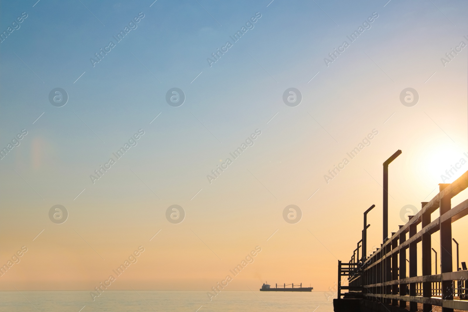 Photo of Picturesque view of pier near sea with boats at sunrise