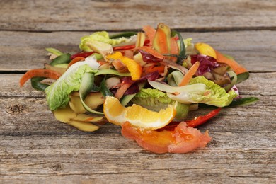 Photo of Peels of fresh vegetables on wooden table