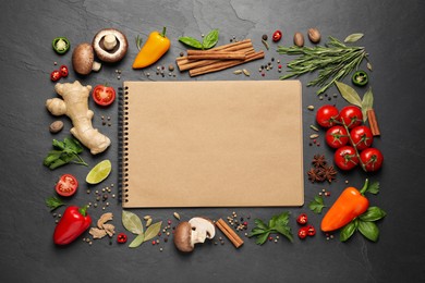Photo of Open recipe book and different ingredients on black table, flat lay. Space for text