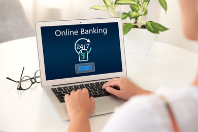 Image of Woman using online banking application via laptop at table, closeup