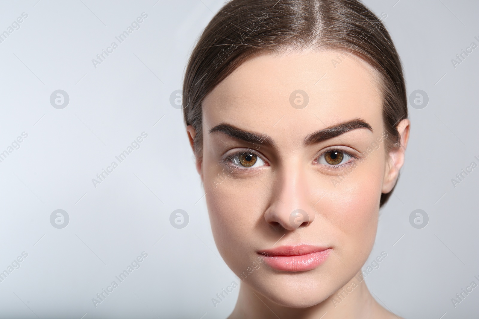 Photo of Beautiful woman with perfect eyebrows on light background