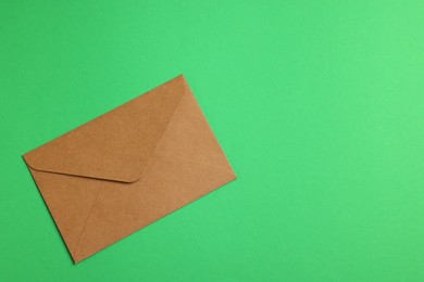 Photo of Envelope made of parchment paper on green background, top view. Space for text
