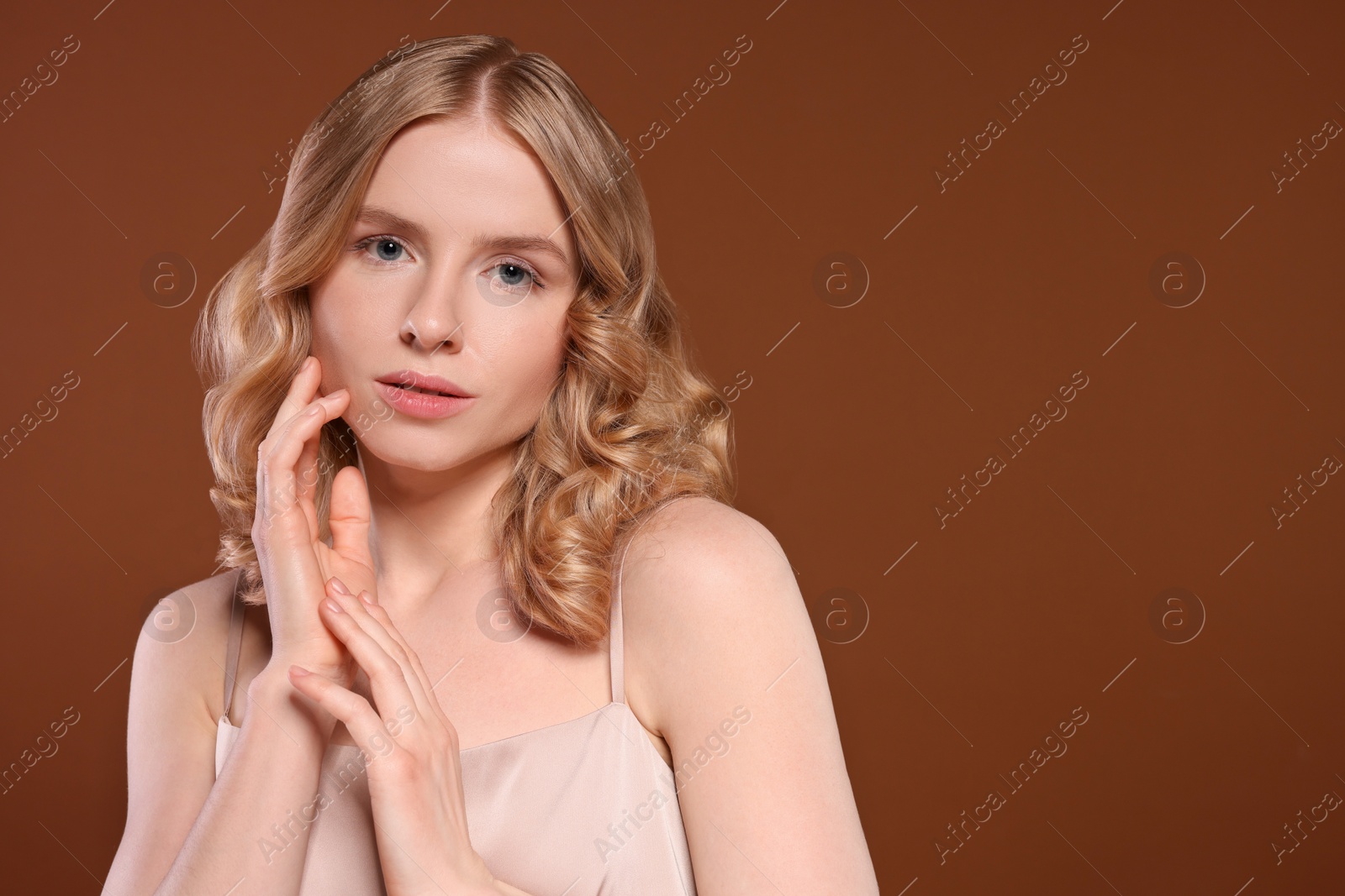 Photo of Portrait of beautiful woman with blonde hair on brown background. Space for text