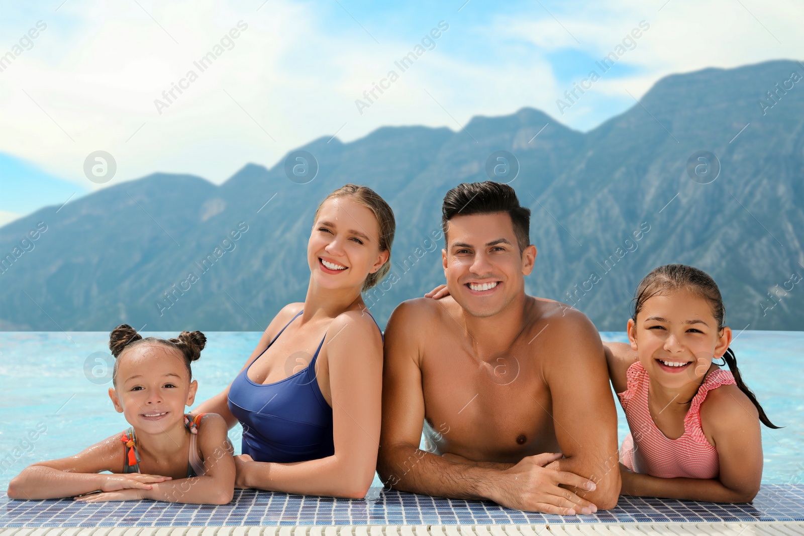 Image of Happy family in outdoor swimming pool at luxury resort with beautiful view of mountains on sunny day