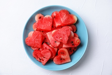 Photo of Plate with heart shaped watermelon slices on light background, top view