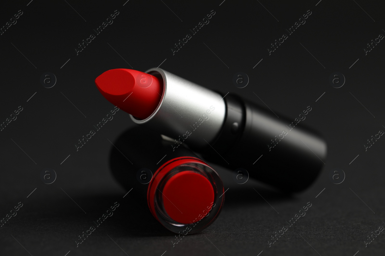 Photo of Beautiful lipstick on black background. Cosmetic product