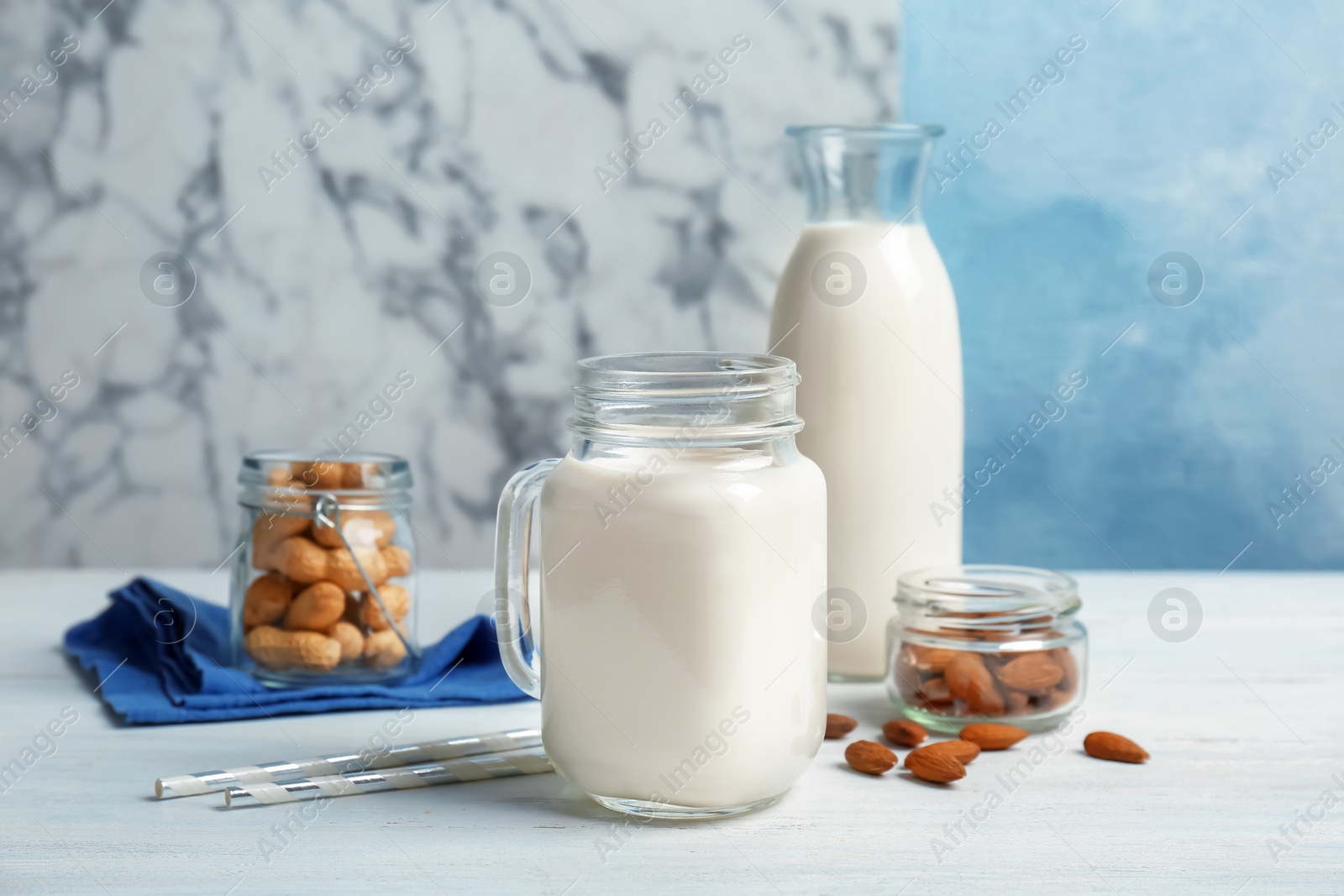 Photo of Almond and peanut milk with nuts on wooden table