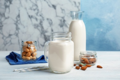 Almond and peanut milk with nuts on wooden table
