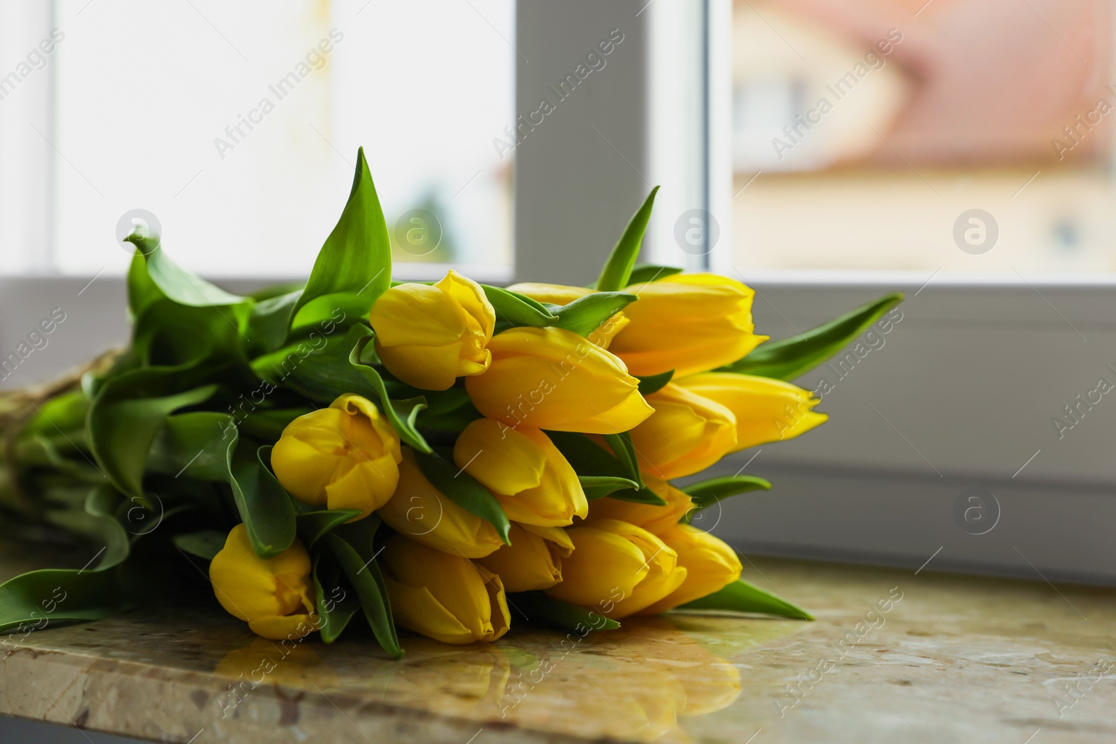 Photo of Bunch of beautiful yellow tulip flowers on windowsill