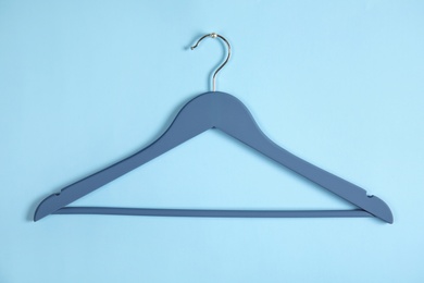 Photo of Empty clothes hanger on color background. Wardrobe accessory