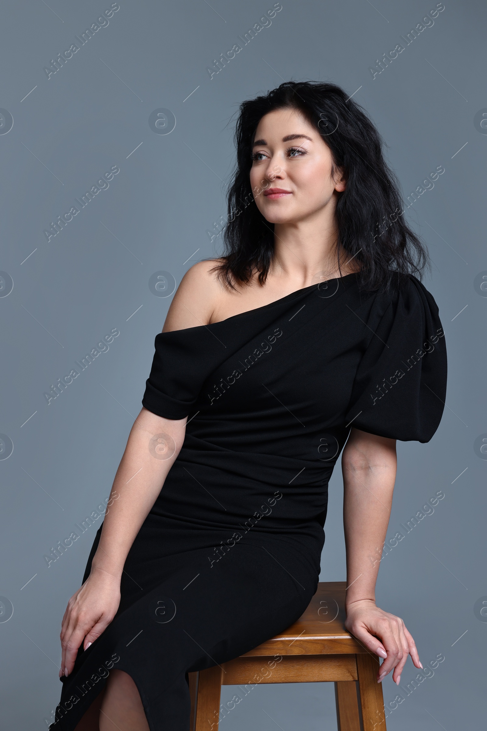Photo of Portrait of beautiful woman in dress on grey background