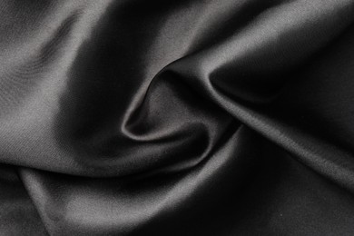 Photo of Crumpled black silk fabric as background, top view